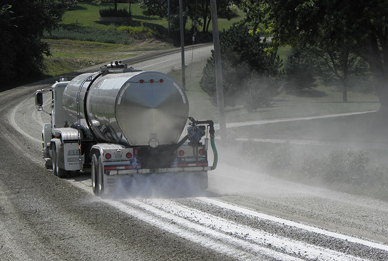 Water tanker dispersing AggreDust solution to the dusty road