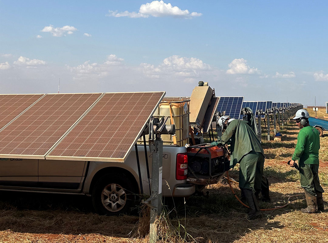 workers cleaning dust from solar panel farm