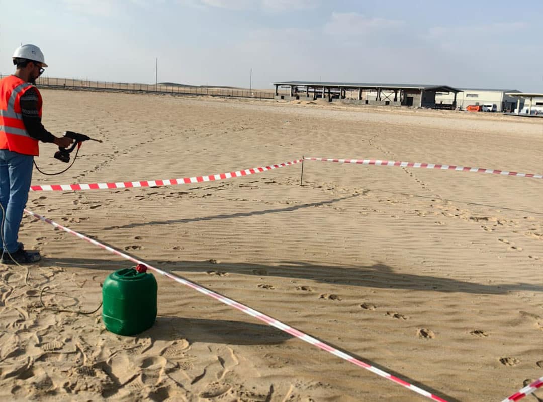 Person spraying AggreDust for topical sand stabilisation