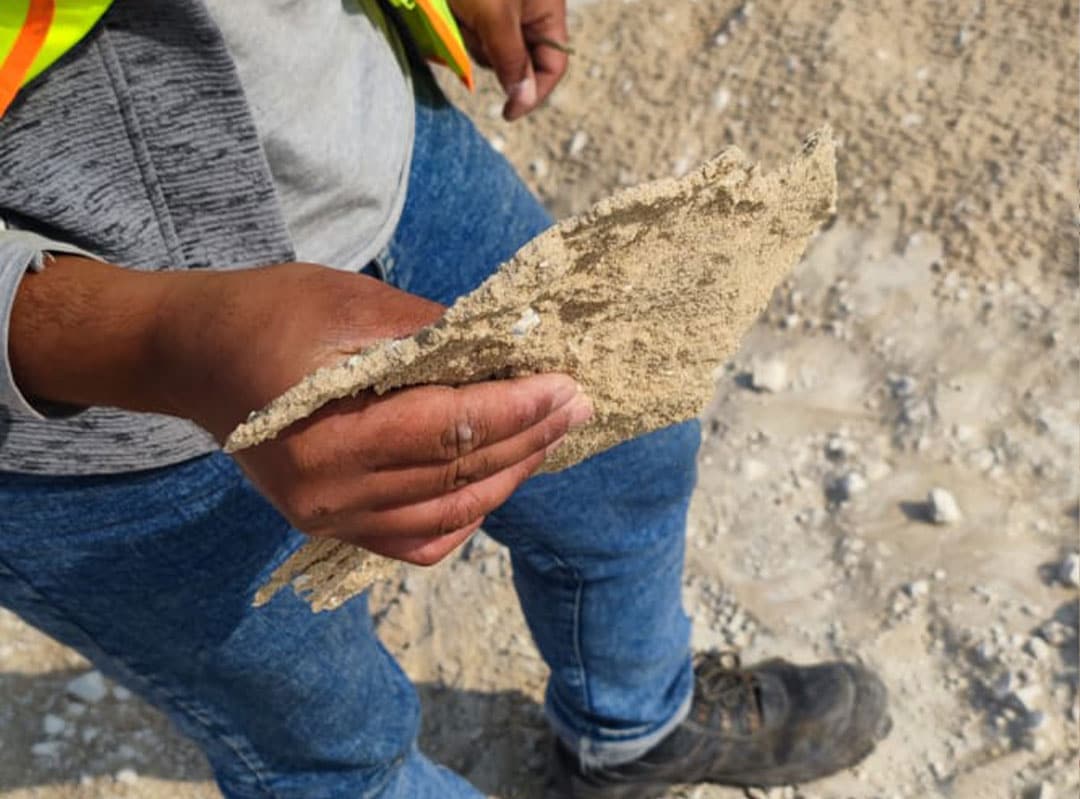 Worker holding AggreDust crust squares from KSA dry port project